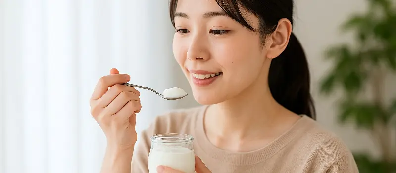 体にいいことを期待してヨーグルトを食べる女性