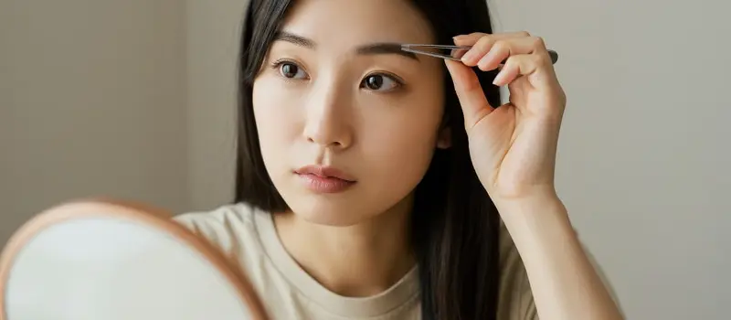 眉毛を抜いている女性