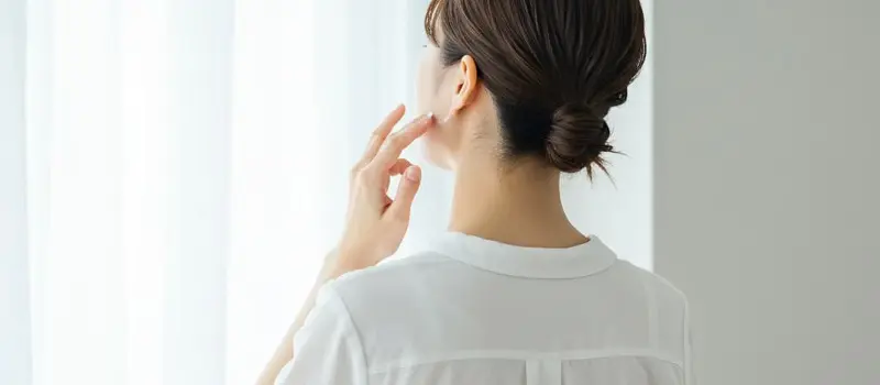 首の後ろにクリームを塗ってしわケアをする女性